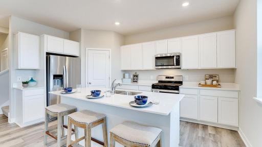Welcome to the Holcombe! Beautiful quartz countertops and stainless steel appliances. *Photo is of a model home, colors may vary in actual home.