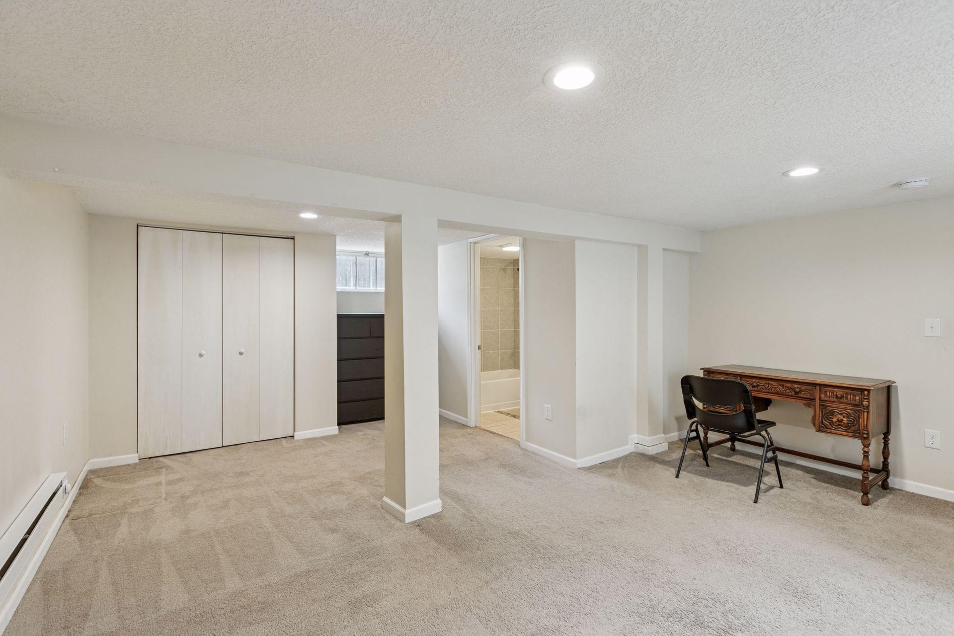 Finished basement with neutral carpeting and paint.