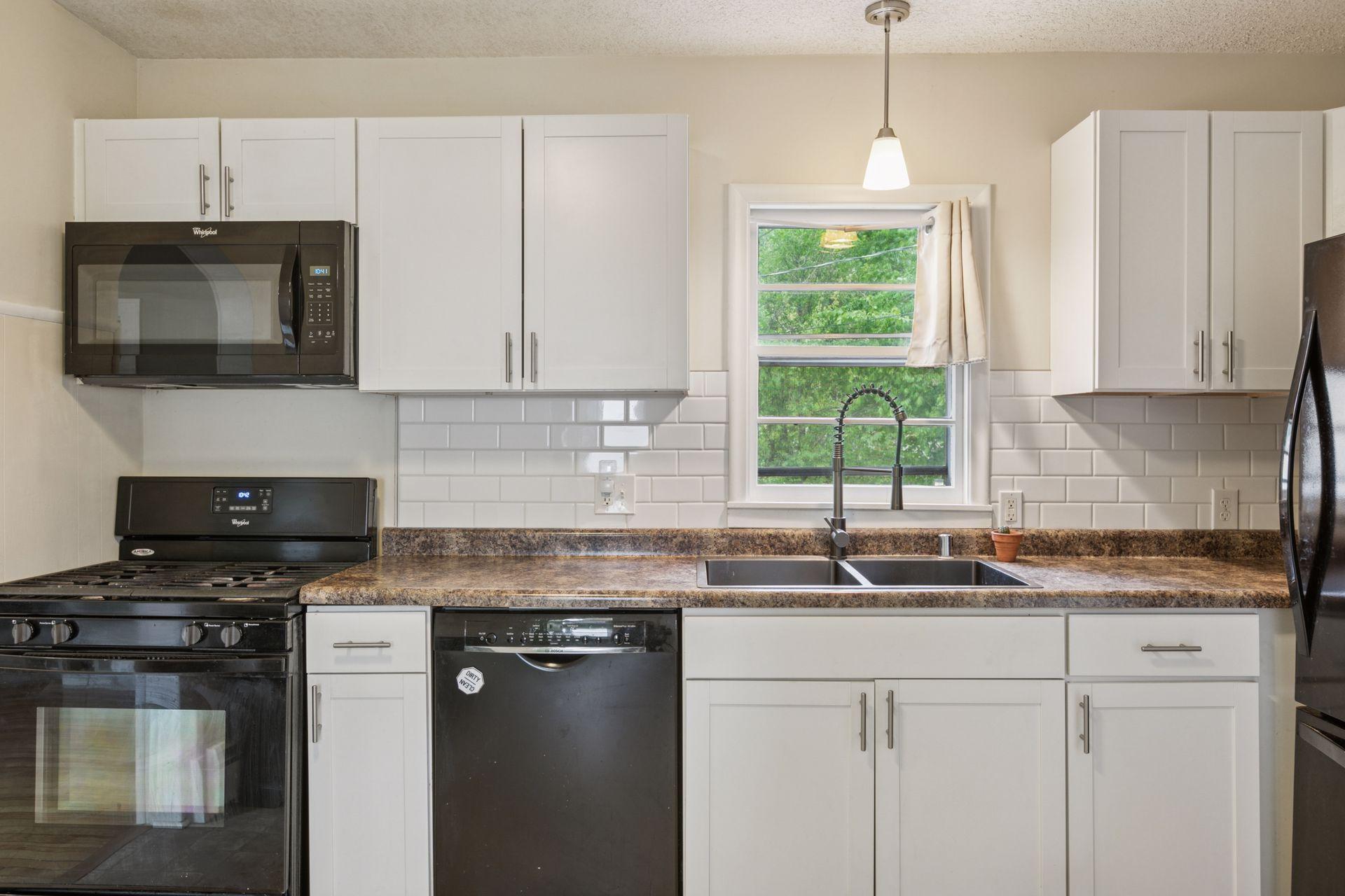 White kitchen cabinetry with updated appliances. Stylish coved doorways.