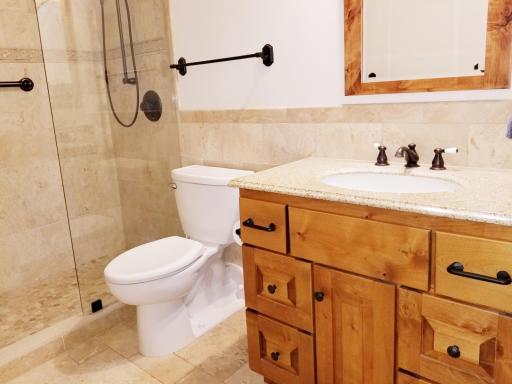 Custom granite vanity with travertine backsplash.