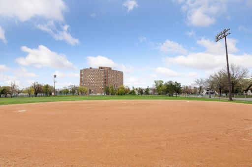 Five acre city park with large community building next door with community rooms, large exercise room, indoor pickleball, racquetball and basketball. Enjoy a baseball field views of the first baseline views from condo 310.