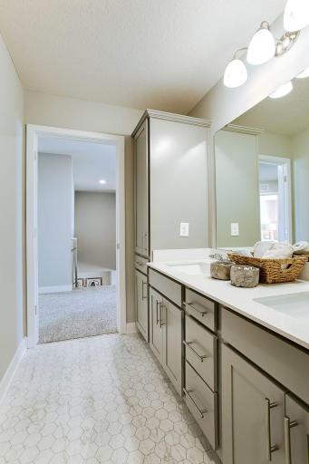 Hall bathroom with double vanity and built in linen closet. Separate bath/shower and toilet area. *Photos of a similar home. Colors and options may vary.