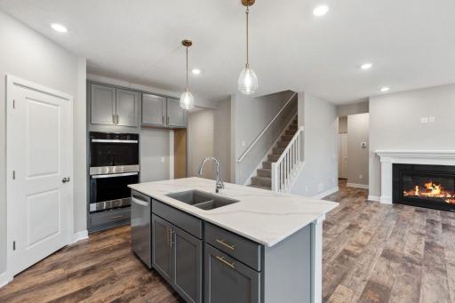 Thoughtfully-designed, modern & fresh describes this kitchen. Equipped with stainless steel appliances, quartz countertops & a large island. Photo of a model home, color & options will vary.