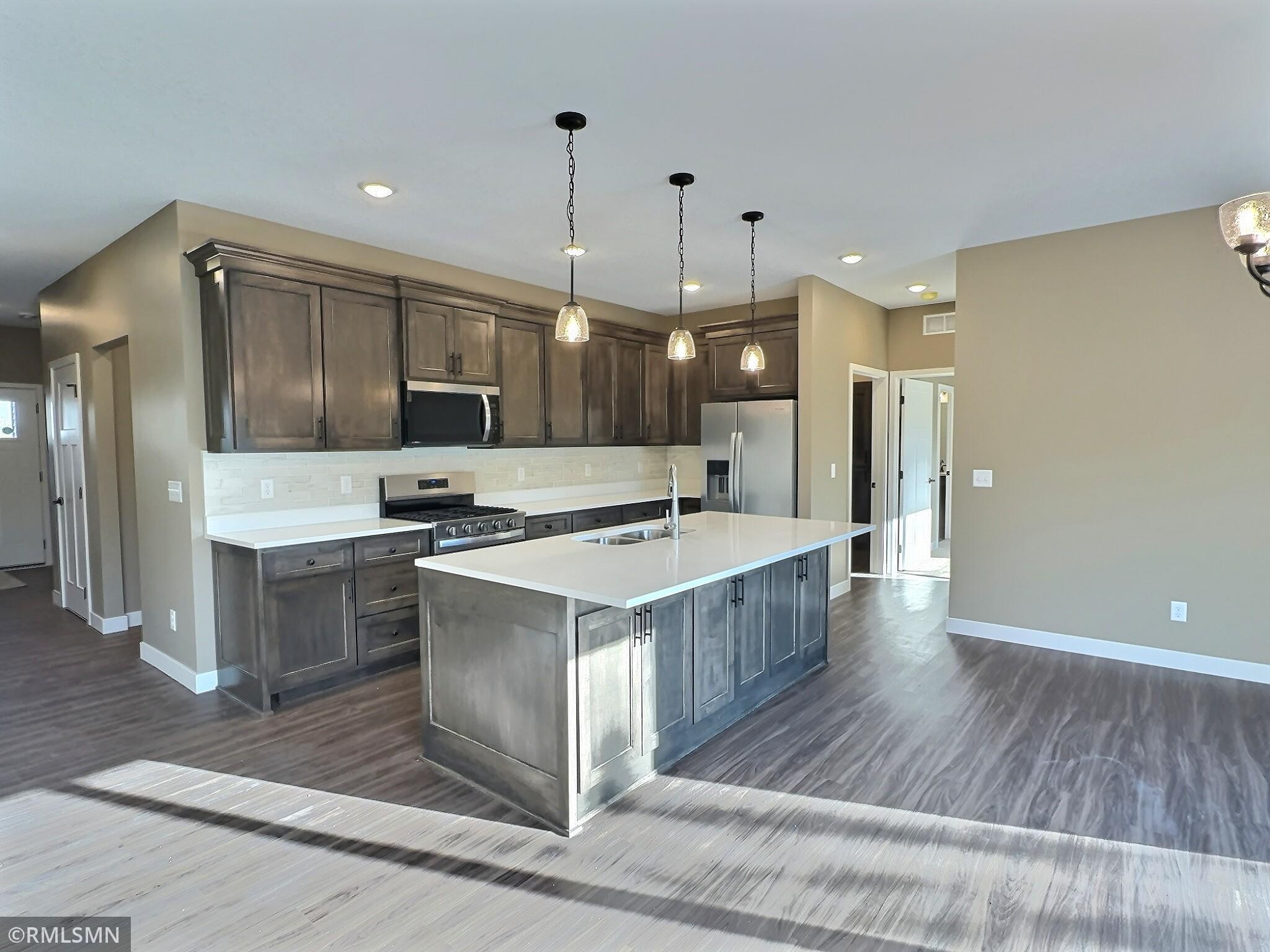 The open and flowing design of this area is ideal for patio home living. The kitchen, featuring a center island, seamlessly connects to the dining and living rooms.
