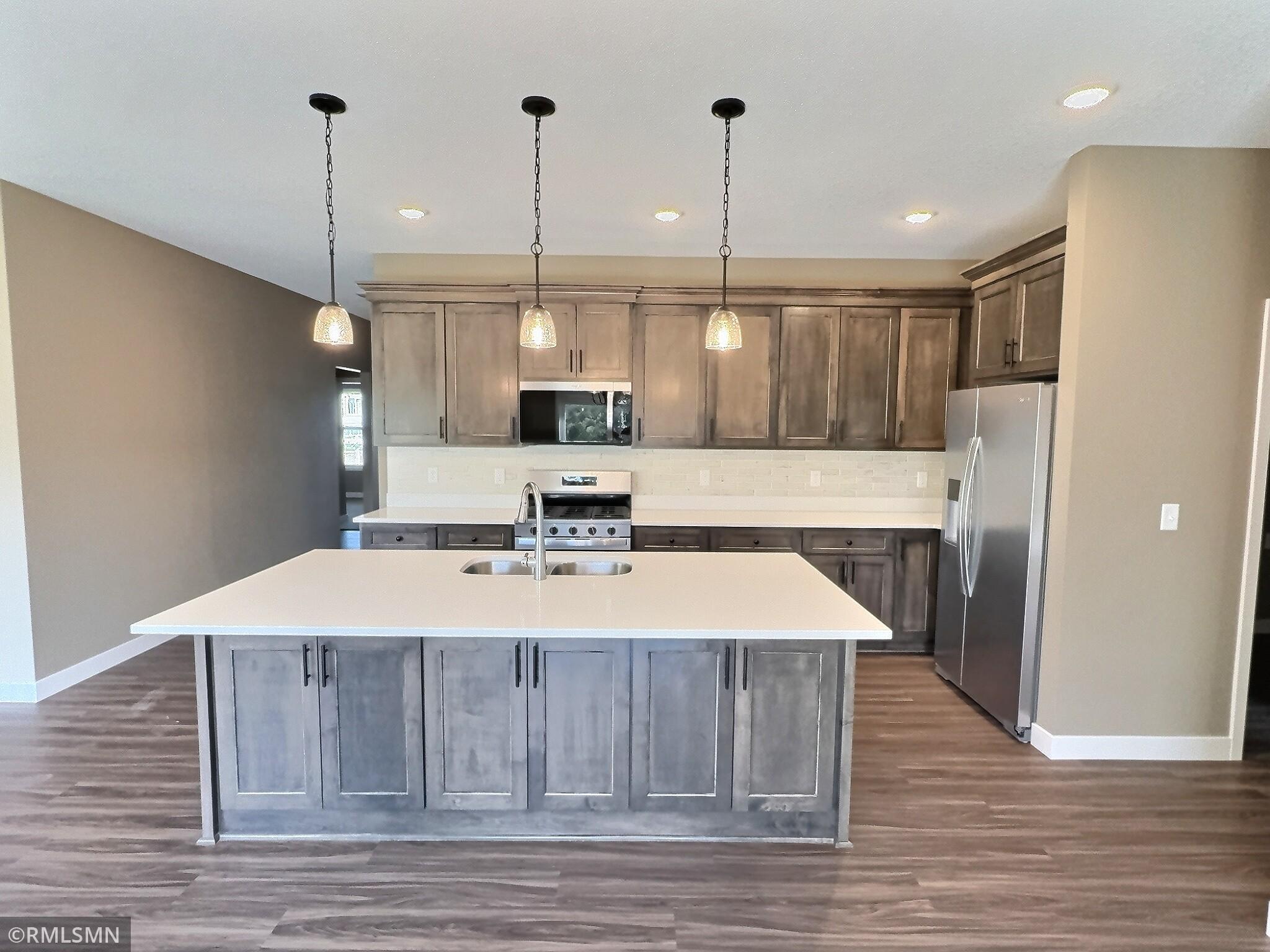 Open design to the kitchen with ample counter space on center island for your work station when prepping meals.
