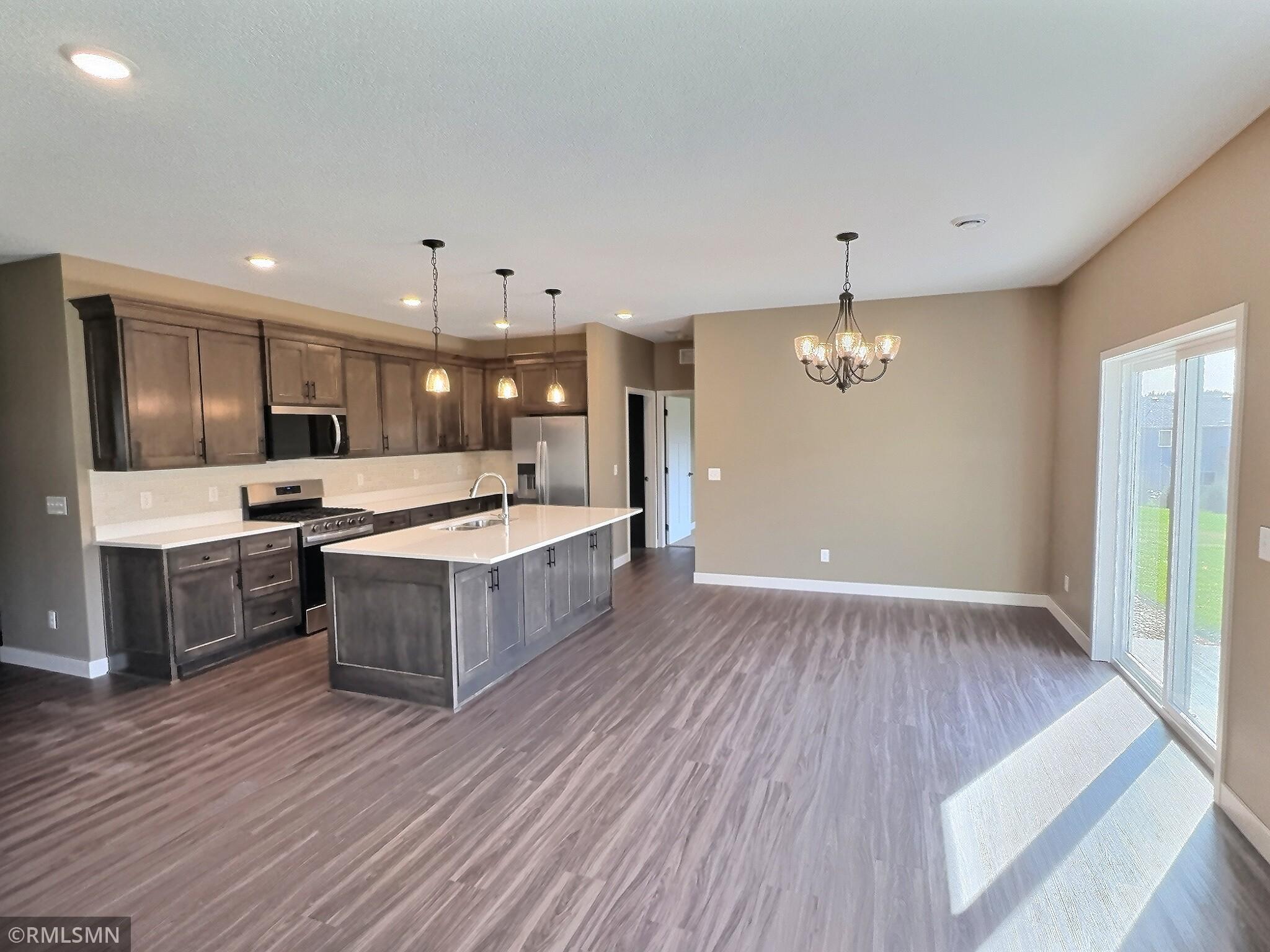 The dining room features patio doors that open to a concrete patio, offering a perfect view of the community park and surrounding woods.
