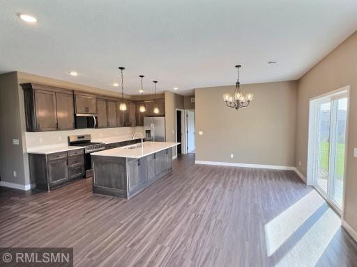 The dining room features patio doors that open to a concrete patio, offering a perfect view of the community park and surrounding woods.