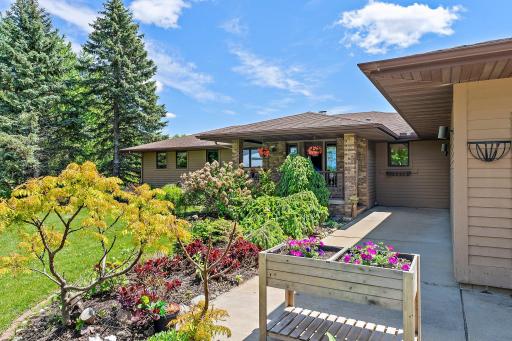 Sidewalk up to the covered porch features gorgeous in-bloom landscaping.