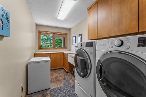 Laundry is located adjacent to the garage entry hallway with folding counter and utility sink, washer and dryer are included.