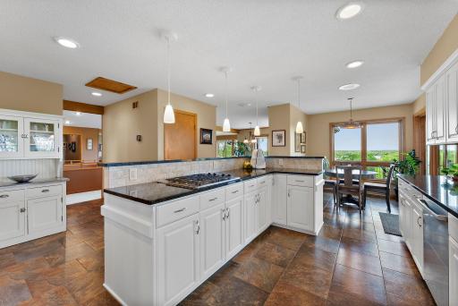 Light and Bright Chef's Kitchen with Tile Flooring, Crisp White Cabinetry and Granite Countertops.