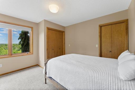 Bedroom 3 on lower level with large corner windows, dual closets and overhead lighting.