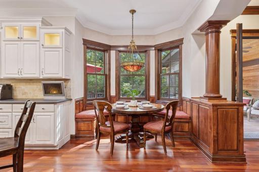 Rich millwork surrounds the eat-in kitchen with bench seat.