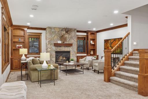 A gas fireplace flanked by built in bookshelves and cabinetry.