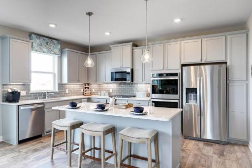 The heart of your home, the kitchen, is perfectly suited for everyday enjoyment and hosting. Quartz countertops, subway tile backsplash, stainless steel double ovens, gas cooktop, microwave, & dishwasher. Photo of model home; Colors and options vary.