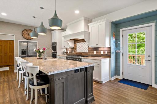 Fully renovated kitchen with Thermodor double ovens, cooktop with 6 gas burners and griddle, 2 dishwashers and access to the deck and back yard