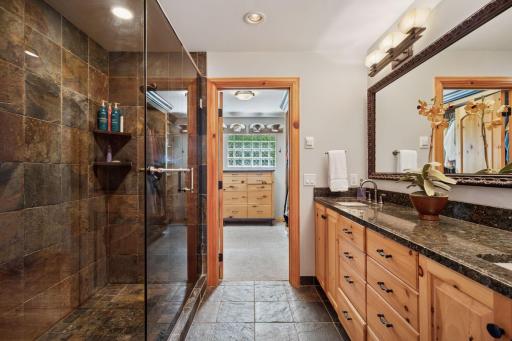 The ensuite bath is divided into 3 spaces: a water closet, a tall double vanity with a glassed-in shower, and a Dressing room closet area.