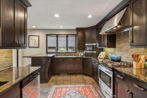 This gleaming kitchen is a chef's haven! Beautiful stone backsplash and an abundance of cabinets.