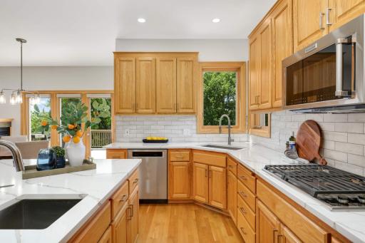 The kitchen features two sinks and a Wolf gas cooktop