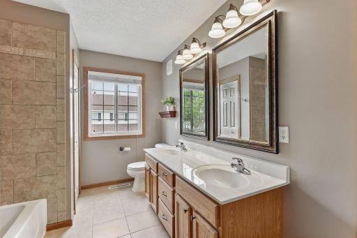 Full upper bath with tile flooring, double sinks and linen closet.