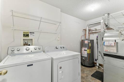 Laundry room with shelving and utility space.