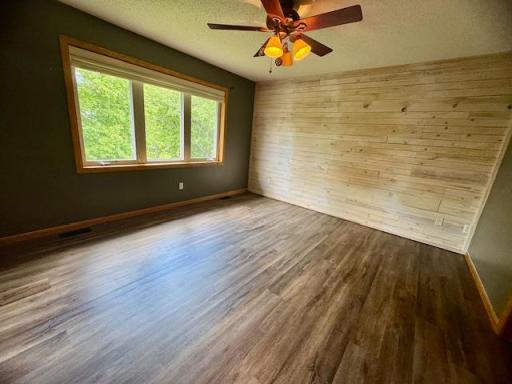 Primary bedroom with fun accent wall and large walk in closet