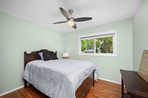 One of three bedrooms on main level with ceiling fan