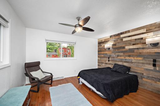 One of three bedrooms on main level with ceiling fan and custom accent wall feature
