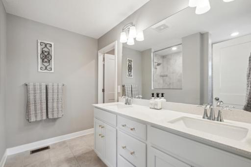 The primary bathroom features dual sinks and ample counter space, making morning routines effortless and efficient.