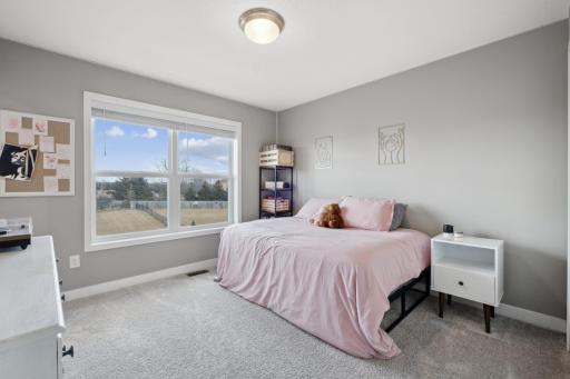 This generously sized bedroom includes its own private full bath, offering both convenience and added privacy.