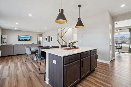 The huge center island shows off a sleek white quartz countertop with room for barstools and built-in cabinets.