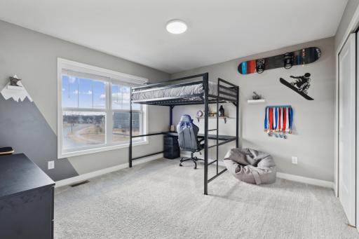 This bedroom with its large window and plush carpeting offers both comfort and style.