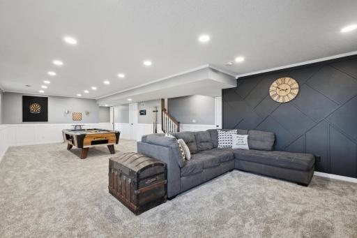 There's plenty of space to play, relax, and entertain in this inviting area, complete with soft carpeting and recessed lighting.