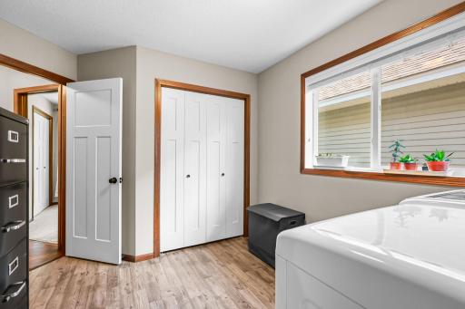 Cheerful, windowed laundry room with closet is located just off the main living space.