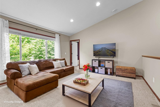 Living area features vaulted ceiling, recessed lighting & large windows!