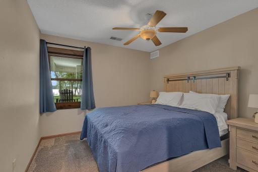Serene lake views from both lower-level bedrooms, perfect for guests, with natural light and a calming atmosphere.