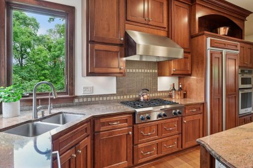 Stainless steel appliances, granite and hood compliment the kitchen