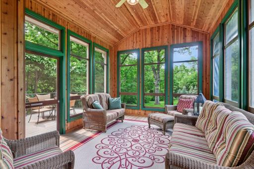 Large screened porch with cedar ceiling and wood floors.