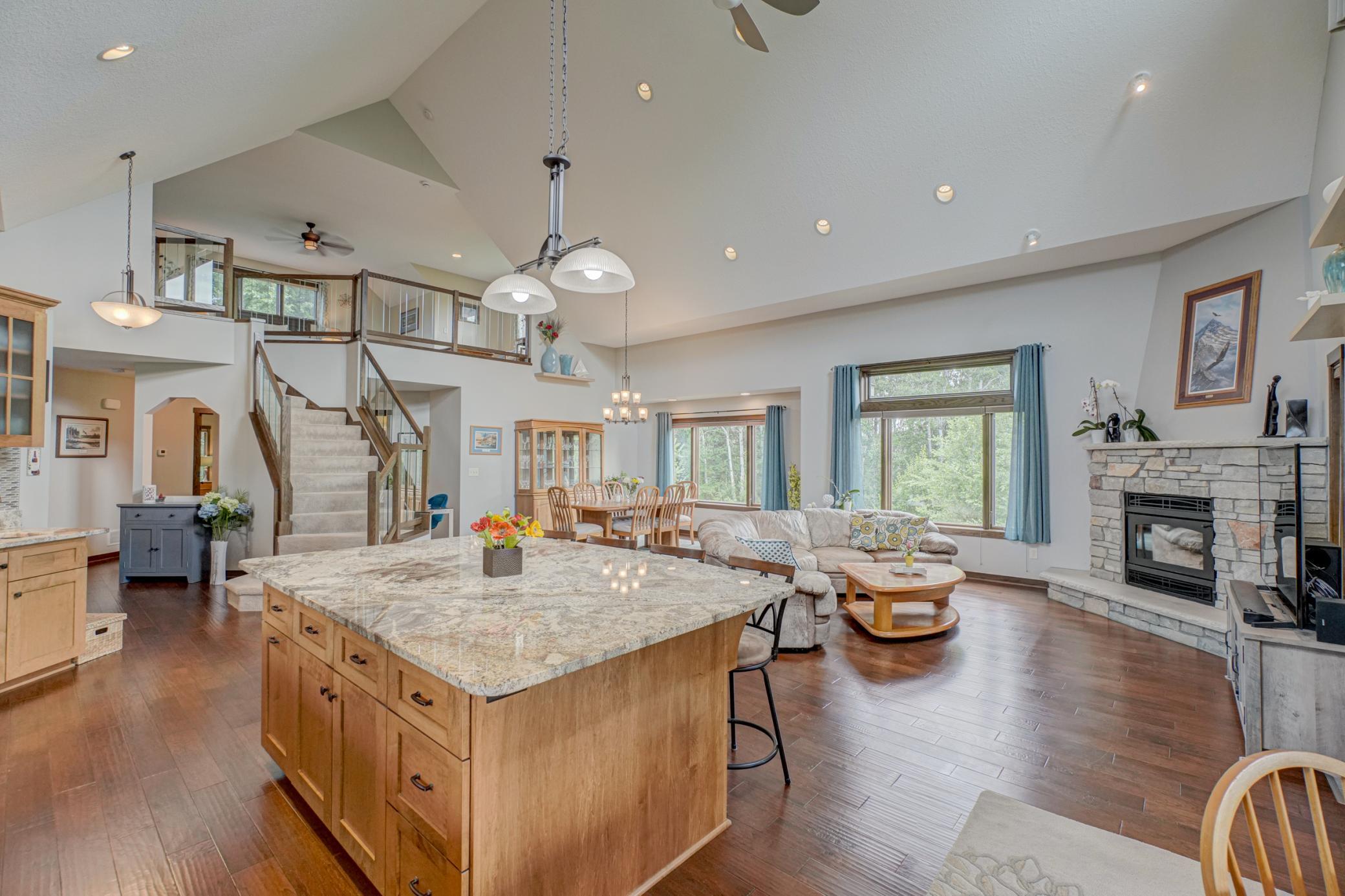 The cozy wood-burning fireplace anchors the spacious living area, which flows seamlessly into the stunning eat-in kitchen featuring granite counters, a large center island.