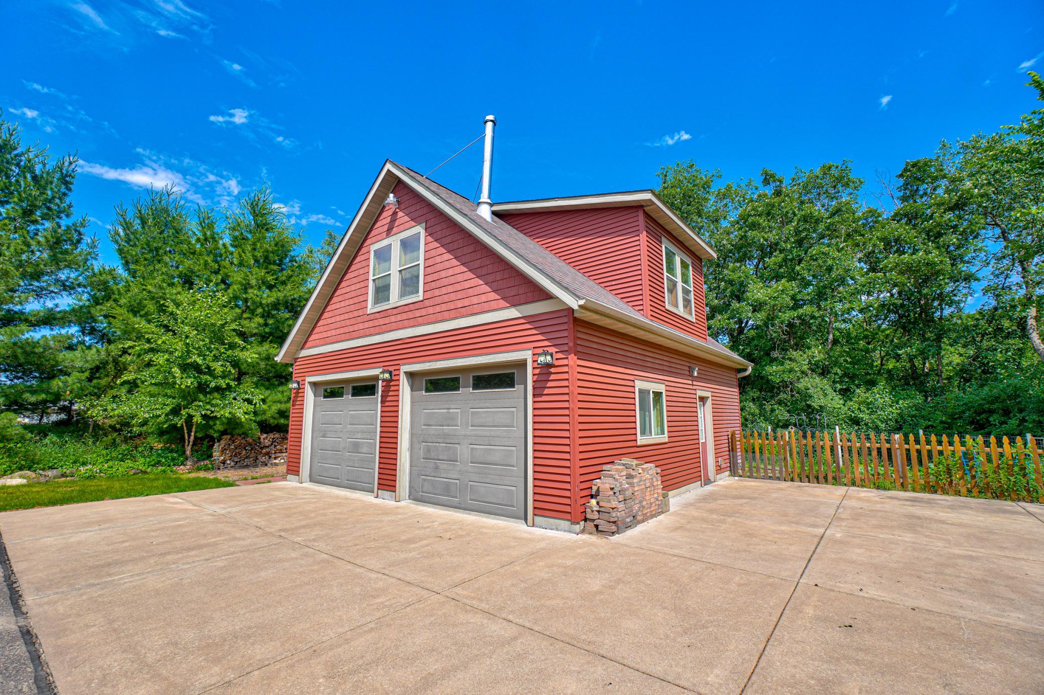 A detached garage/workshop with an additional living area above—including a kitchenette, bathroom, and wood-burning stove—add to the home’s exceptional amenities.