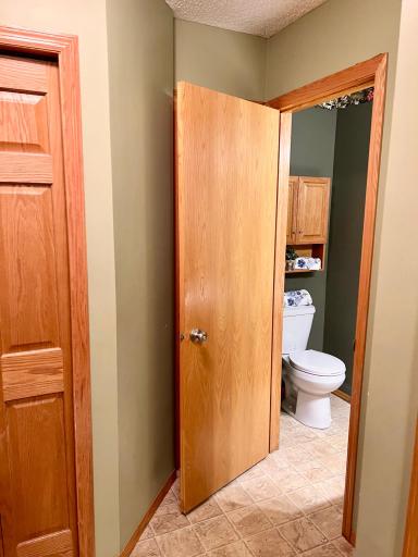 Hallway from the garage entrance to powder room bath and to the right, the kitchen