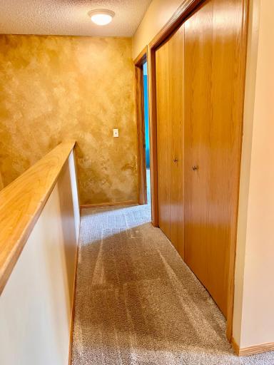 This hallway leads to the owner's suite and shows the laundry closet