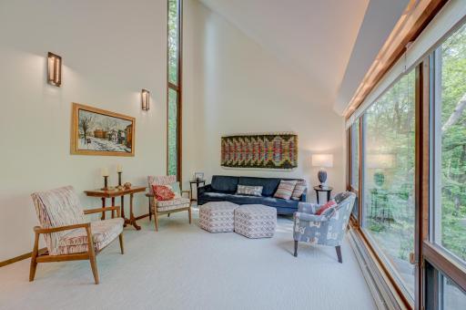 Expansive living room with a wall of windows, soaring vault, and a new (2024) 2-story window in the corner.
