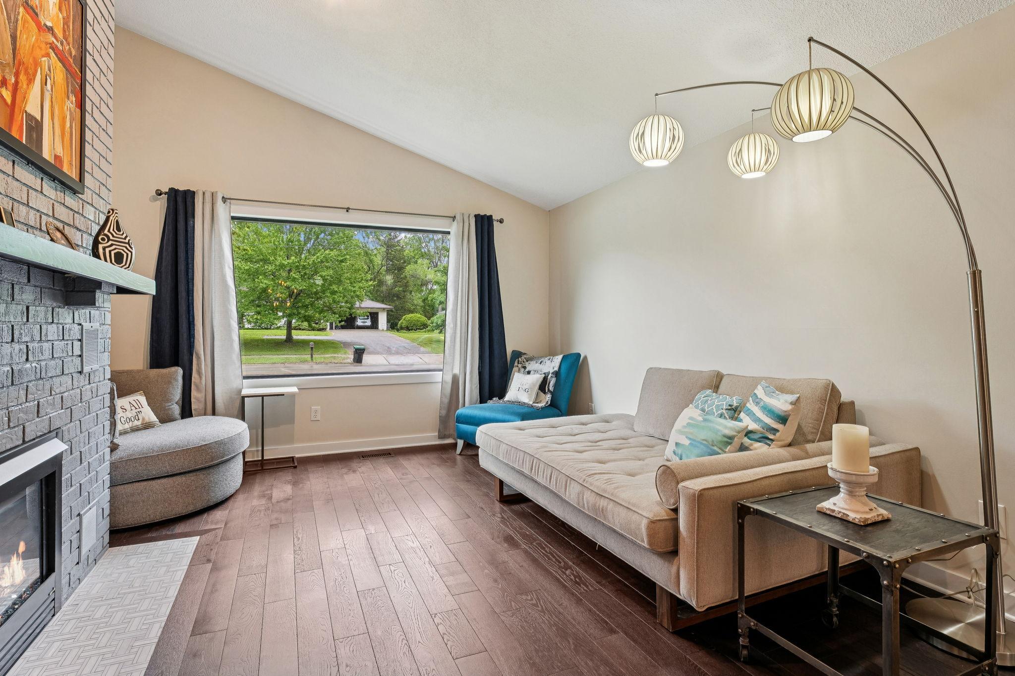Enjoy peaceful quiet views from the oversized front window with triple panes, in this light-filled living room, complete with updated hardwood floors and clean, modern finishes.