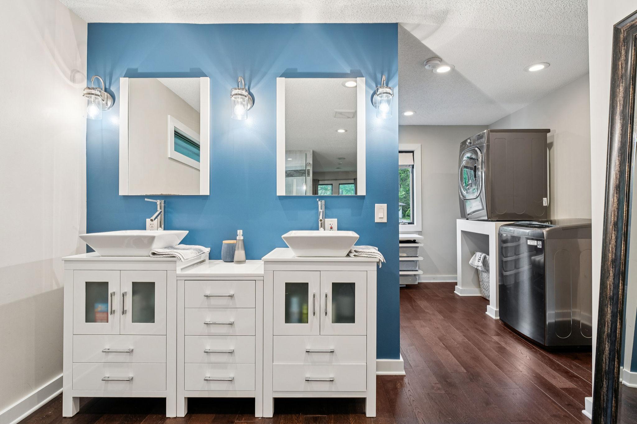 Spa-inspired ensuite with dual vanities, vessel sinks, and a separate water closet. Thoughtfully designed ensuite includes laundry for ultimate convenience.