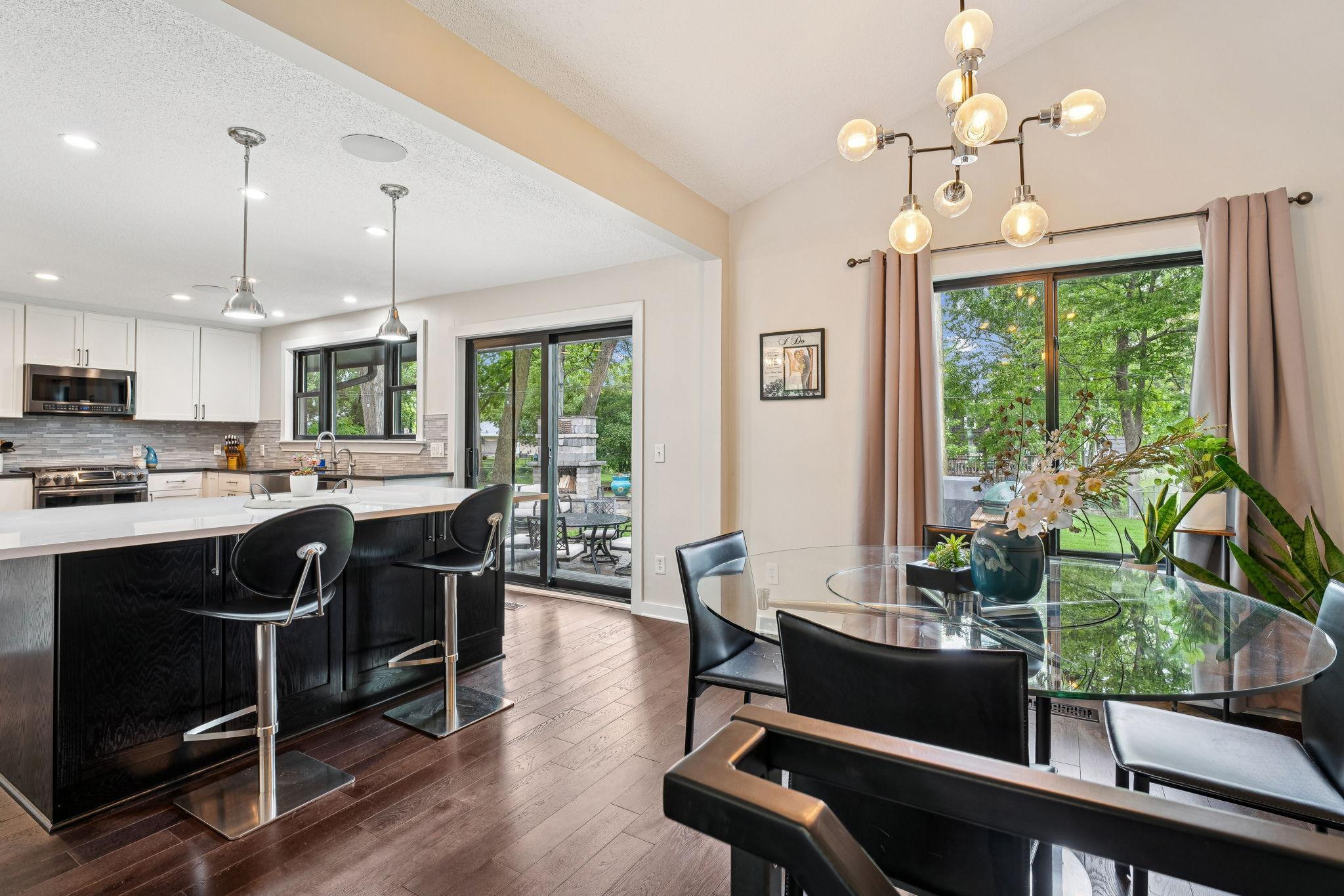 Gorgeous open-concept kitchen and dining area with a large quartz center island, pendant lighting, and rich hardwood floors.