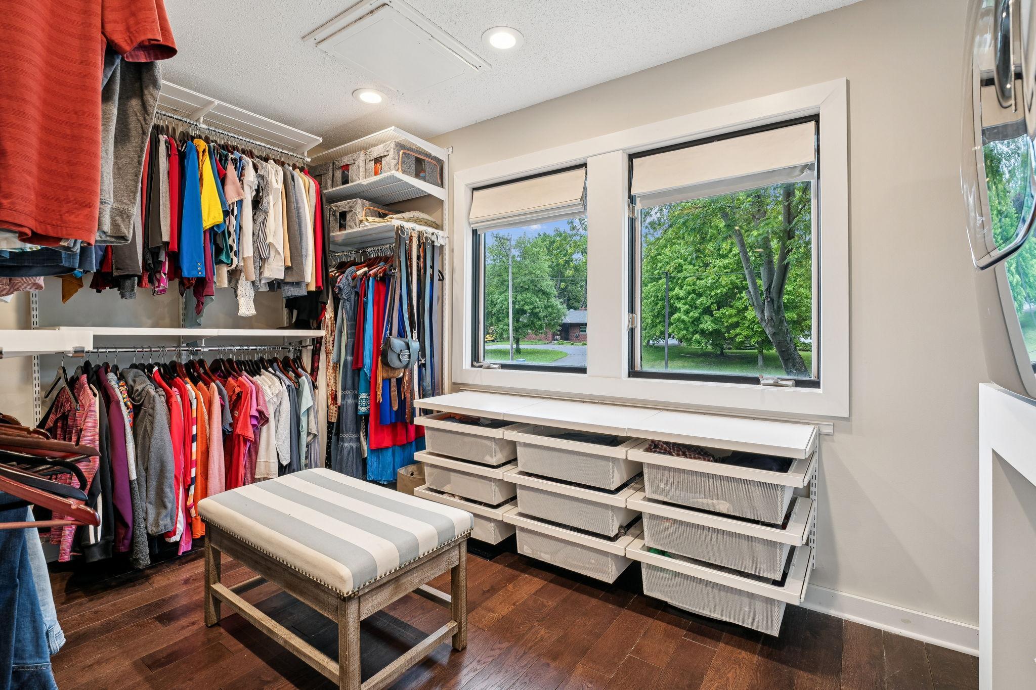 Spacious walk-in closet with built-in shelving and drawers.