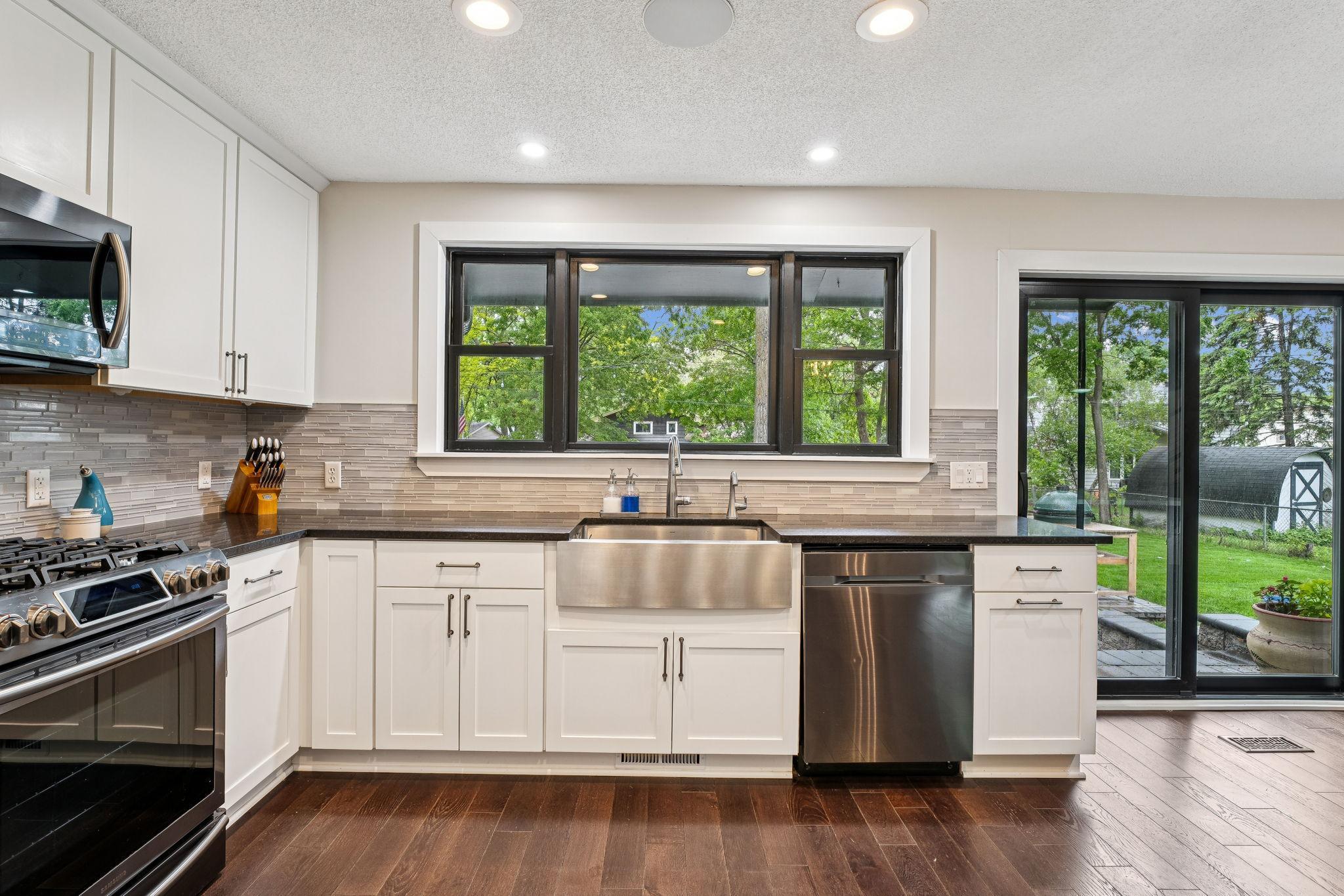 Enjoy peaceful views from the oversized kitchen window above the deep stainless steel farmhouse sink. Clean lines, updated hardware, and ample prep space make this kitchen standout.