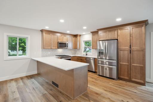 The Remodeled Kitchen is a Chef's Dream with Quartz Countertops, Slow-Close Maple Cabinetry, Oversized Breakfast Bar and New SS Whirlpool appliances