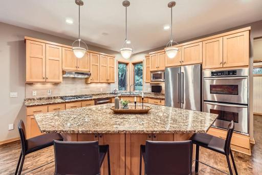 Lovely kitchen is open and airy - tons of meal prep and storage space. Large center island offers generous dining and storage space. Custom Maple cabinets and solid maple floors.
