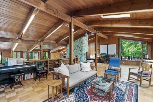 On the highest level, a huge family room with a wall of windows provides views of Cedar Lake, a balcony, and a built-in seating area for enjoying the striking green-tiled fireplace that runs through the home.